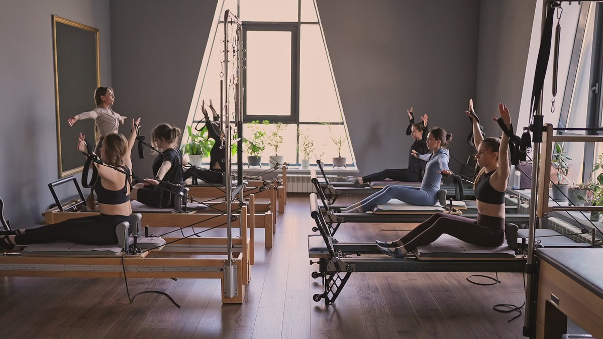 Load video: A Pilates session in a studio setting