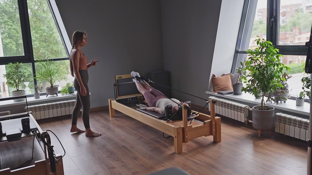 Load video: A Pilates session in a studio setting
