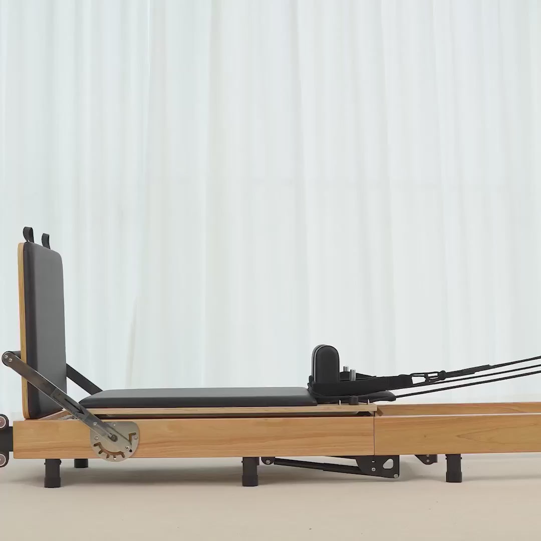 Load video: Close-up detail of the Reformesa Oak Foldable Pilates Reformer frame, rails, springs and upholstery